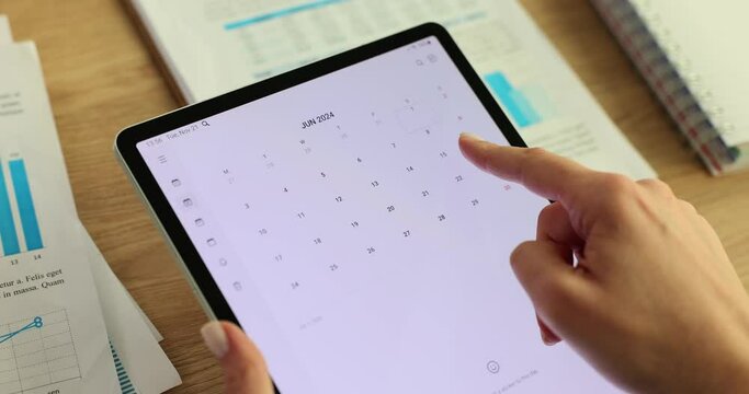Woman uses a tablet to plan events and calendar