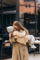 Fototapeta premium young happy mother hugs her daughter in the city
