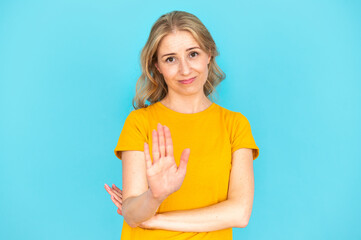 Young woman making hand stop sign, showing disagreement gesture
