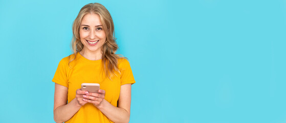 Young happy woman with modern cell phone downloading online application