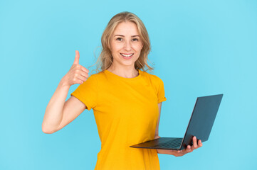 Student showing thumb up or approving gesture, holding computer
