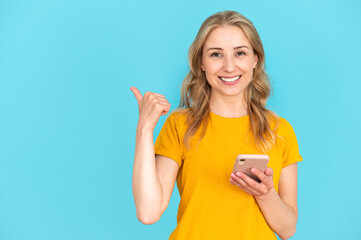 Smiling woman using mobile app and showing place for advertising,