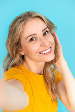 Happy smiling woman making selfie over blue background