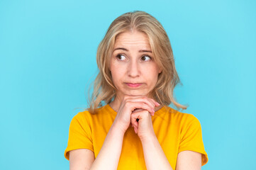 Portrait of offended woman looking to the side on blue background