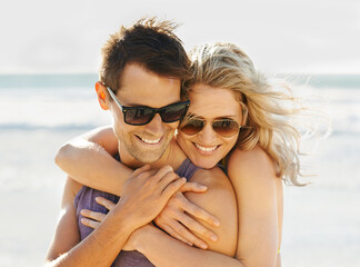 Happy couple, hug and sunglasses at beach with sunshine for summer vacation, honeymoon and...