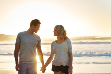 Holding hands, sunset and couple with love at beach, ocean and sea for affection, bonding or to...