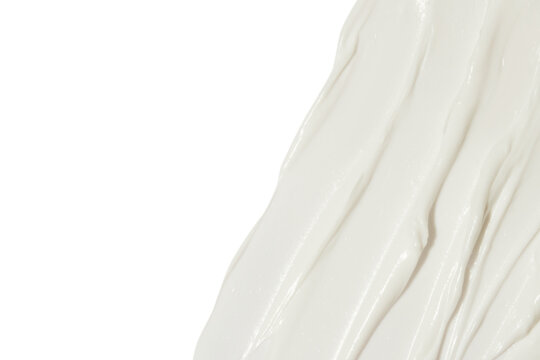 White cosmetic cream smeared on a blank background.