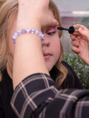 A makeup artist makes makeup for a child 