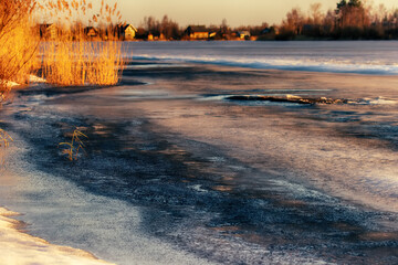North-eastern European river after frosty winter. Porous ice began to melt, river is swollen, state...