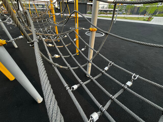 A vibrant playground scene with colorful equipment like ladders and ropes, inviting children to climb and play.