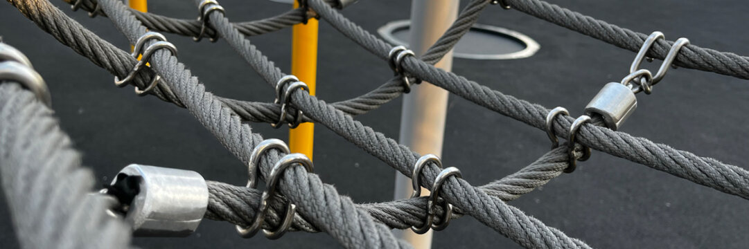 An abstract close-up of climbing rope equipment against a textured background, embodying strength and adventure.