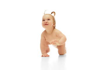 Happy, smiling little baby girl, child in diaper crawling isolated on white studio background. Playing and having fun. Concept of childhood, care, health, well-being, parenthood