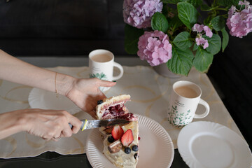 cup of coffee with cake. Top view of a piece of cake being cut into pieces