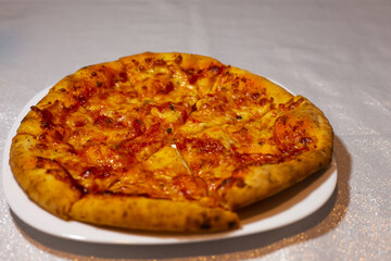 Original Italian pizza Margherita with cheese and tomato sauce on a white plate