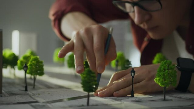 Architect. A male worker equipped with tools carefully creates new buildings in a modern development center. Close-up of a construction designer busy planning a future city, sustainable city concept