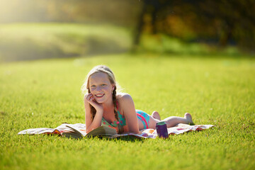 Portrait, girl or book on grass, reading or imagine by story, freedom or vacation at summer camp....