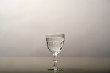 An empty transparent glass cup on a glass surface