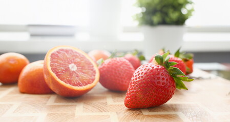 Strawberry and red orange on kitchen table closeup