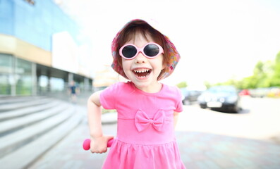 Happy smiling girl child in sunglasses outdoor portrait. Childhood concept.