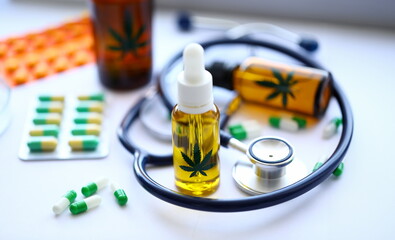 Marijuana stethoscope oil pills are on table at the doctor. Purpose of narcotic drugs concept