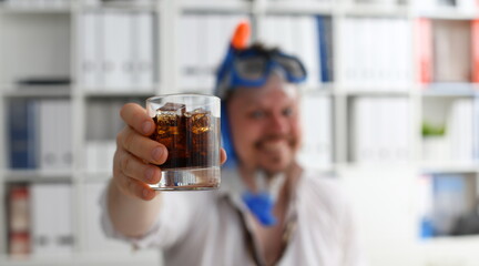 Man wearing suit and tie in goggles and snorkel hold in arm glass of cola at workplace in office closeup. Count days to leave annual day off workaholic resort idea ticket sale concept