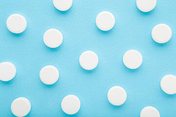 White pills of c vitamins on light blue table background. Pastel color. Closeup. Nutritional supplements pattern. Top down view. - 783033204
