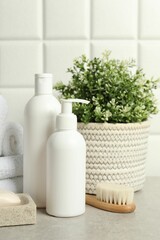 Different bath accessories and personal care products on gray table