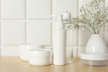 Bath accessories. Different personal care products and gypsophila flowers in vase on wooden table...