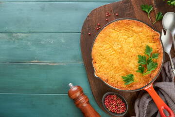Shepherd's Pie with ground beef, peas, carrots, onions, potato and cheese on old wooden background...