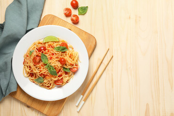 Vegetarian meal. Tasty pasta with fresh tomatoes and basil on wooden table, flat lay. Space for text