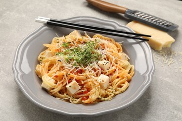 Vegetarian meal. Tasty pasta with fresh microgreens and cheese on light grey table