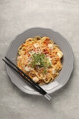 Vegetarian meal. Tasty pasta with fresh microgreens and cheese on light grey table, top view
