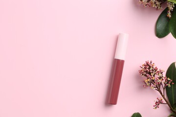 Bright lip gloss and flowering branches on pink background, top view. Space for text