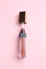 Bright lip gloss on pink background, top view