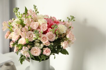 Beautiful bouquet of fresh flowers in vase near white wall indoors, space for text