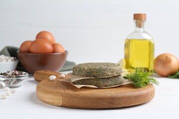 Vegetarian product. Uncooked bean cutlets and ingredients on white wooden table