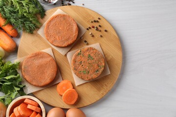 Vegetarian product. Uncooked carrot cutlets and ingredients on light wooden table, top view. Space for text