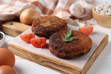 Vegetarian product. Tasty bean cutlets served on white wooden table, closeup
