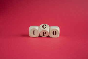 ICO and IPO symbol. Wooden cubes with words ICO - initial coin offering and IPO - initial public...