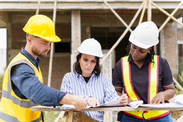 Team of construction workers discussing about the building construction plan.