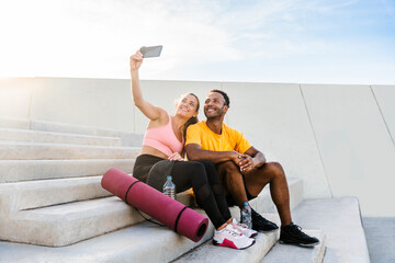 Multiethnic sportive couple training outdoor - Athletic hispanic man and caucasian woman doing sport fitness workout at the city streets