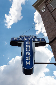 Birmingham Alabama, USA - May 16, 2019 View of the neon sign on the side of the Sixteenth Street Baptist Church against a blue sky and clouds, vertical aspect