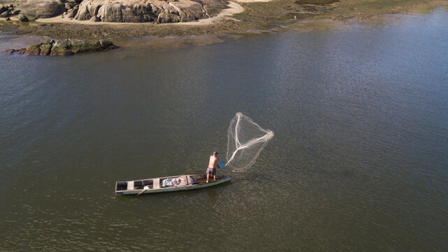 Pescador joga tarrafa no canal de Camburi, em vitória, Espírito Santo, Brasil.
