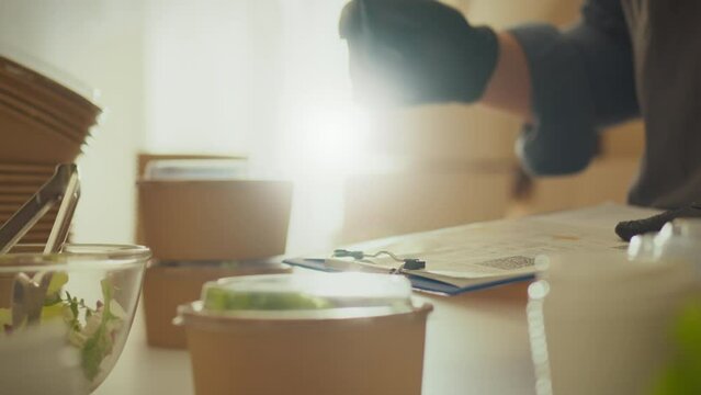Container. A white woman concentrates on marking data on a piece of paper in a warehouse logistics room. Grocery delivery staff checks and counts introducing a zero-waste lifestyle, home delivery