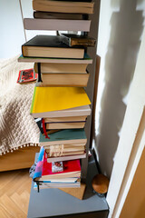 A bedside table with many books