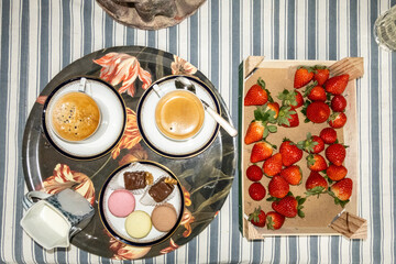 Vienna, Austria  A tray of coffee with Viennese sweets and strawberries in a box on a table.