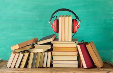 Large heap of books and heaphones, audio books concept, entertainment,education and e learning on teal background,free copy space. - 783062637