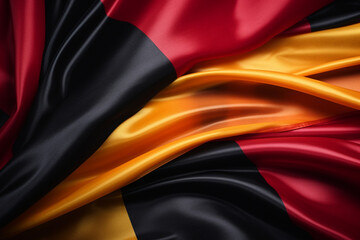 Close-up of the German flag's rich, silky fabric showcasing the deep black, red, and gold colors....