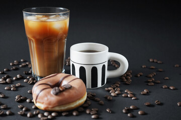 Caramel donut with coffee decoration next to a glass of iced frappuccino with a cup of black coffee...