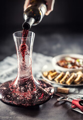 Red wine is poured from a bottle into a carafe on a table on which there is venison, Hungarian or Viennese goulash with Karlovy Vary dumplings - 783068632